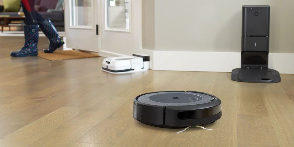 Een zwarte Roomba met een witte op de achtergrond